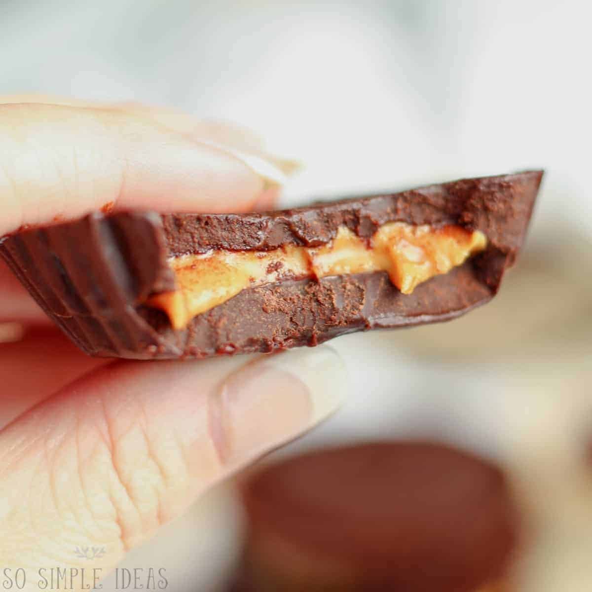 dairy free vegan peanut butter cup bitten in hand