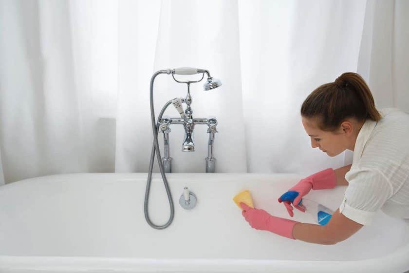 woman scrubbing the bathtub