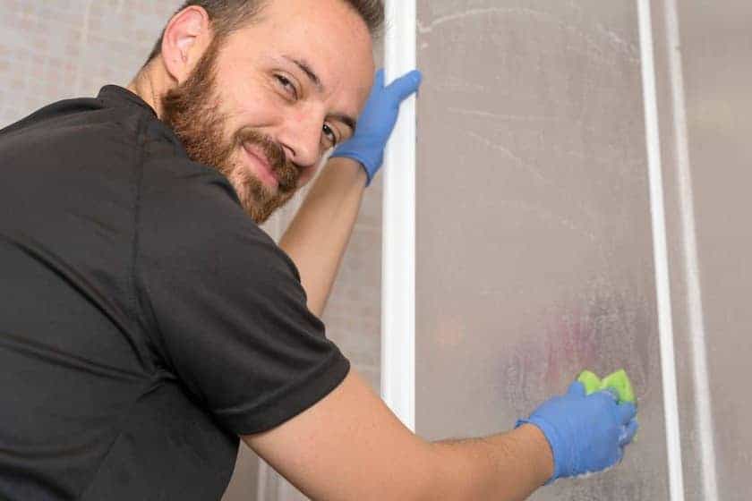 man wiping down shower