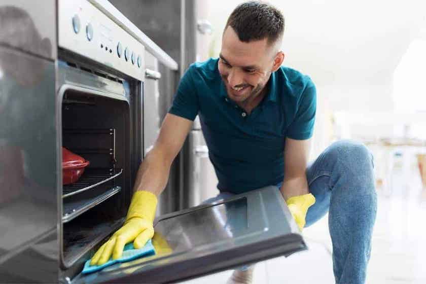 man cleaning oven.