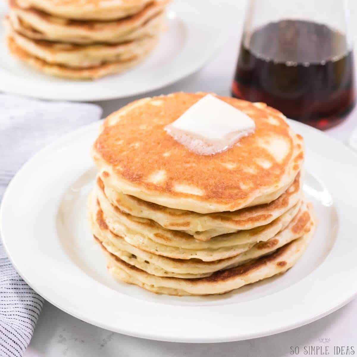 carbquik pancakes on white plates with syrup in container