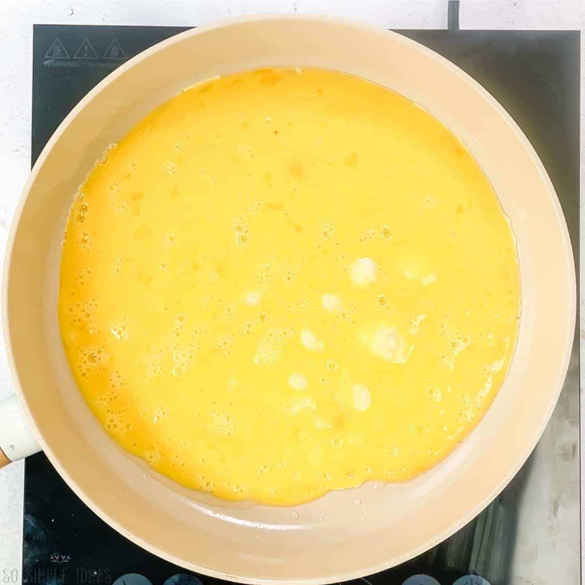 cooking scrambled egg in pan.