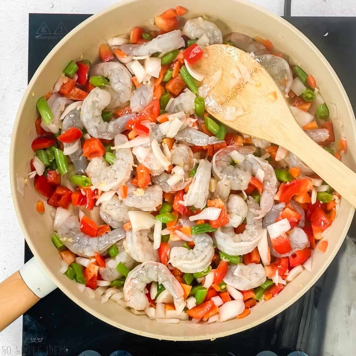 cooking the shrimp with vegetables.