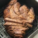 air fryer roast beef sliced in air fryer basket.