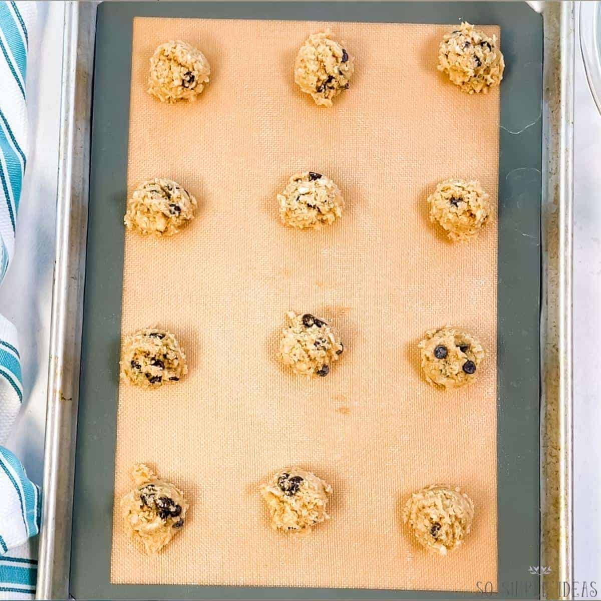 cookie dough scoops on lined baking sheet.