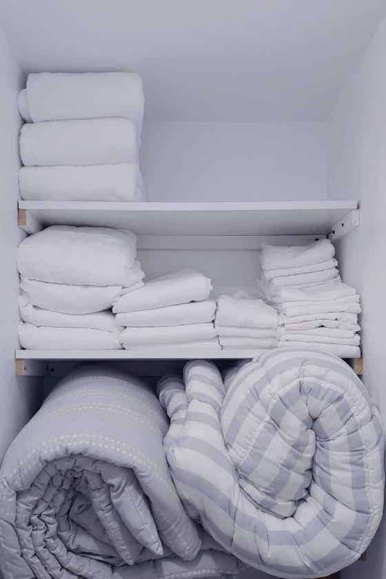 comforters stored on bottom shelf.