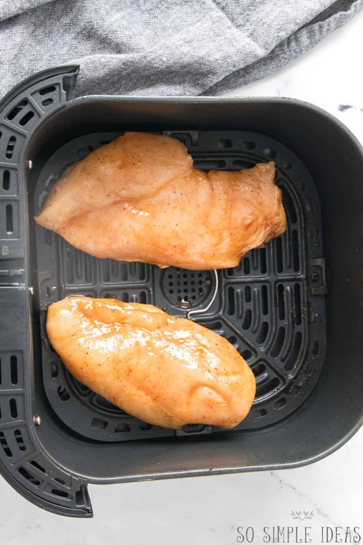 marinated chicken breasts in air fryer basket.