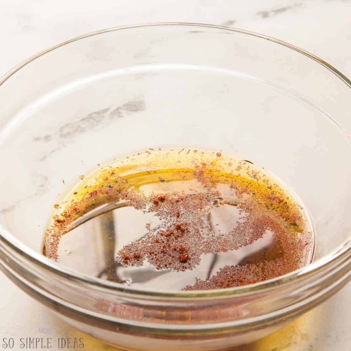 seasonings and olive oil in small glass mixing bowl.