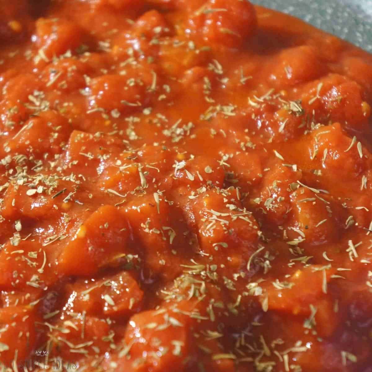 diced tomato with seasoning in pan.