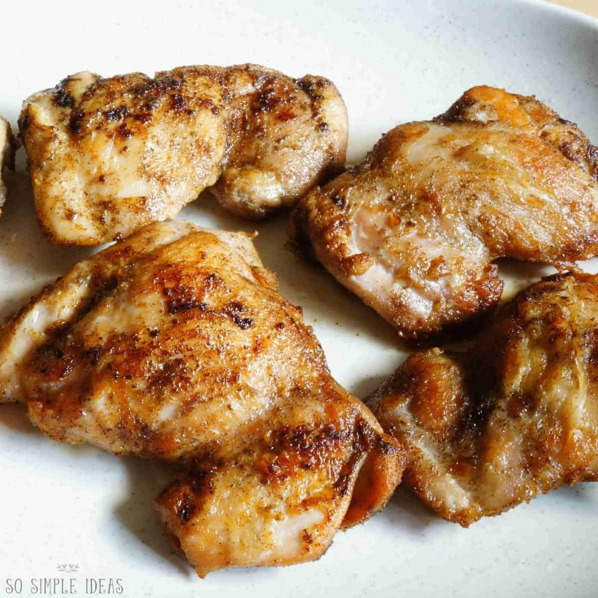 pan fried boneless chicken thighs on white plate.