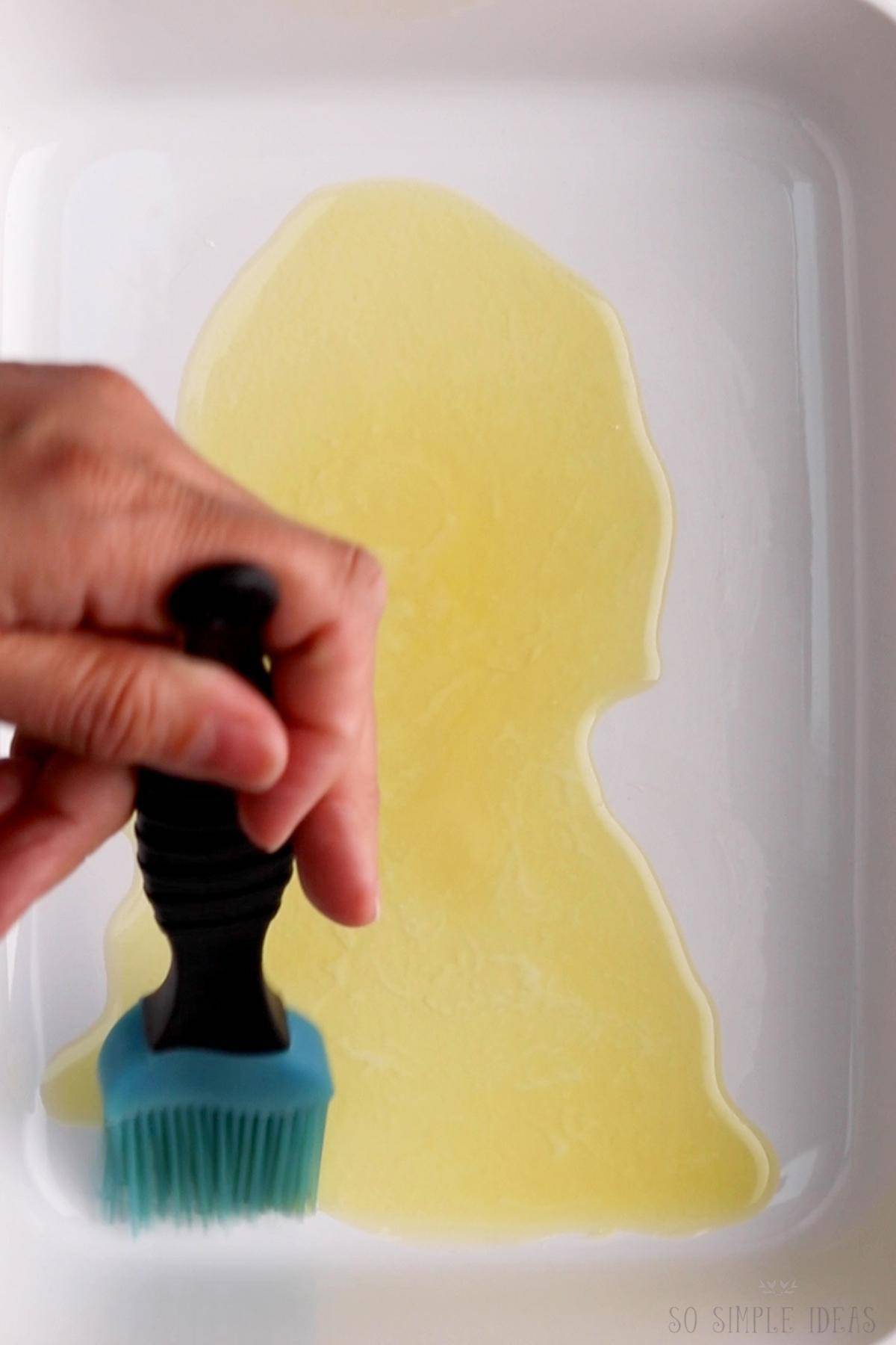 brushing melted butter on bottom of casserole pan.