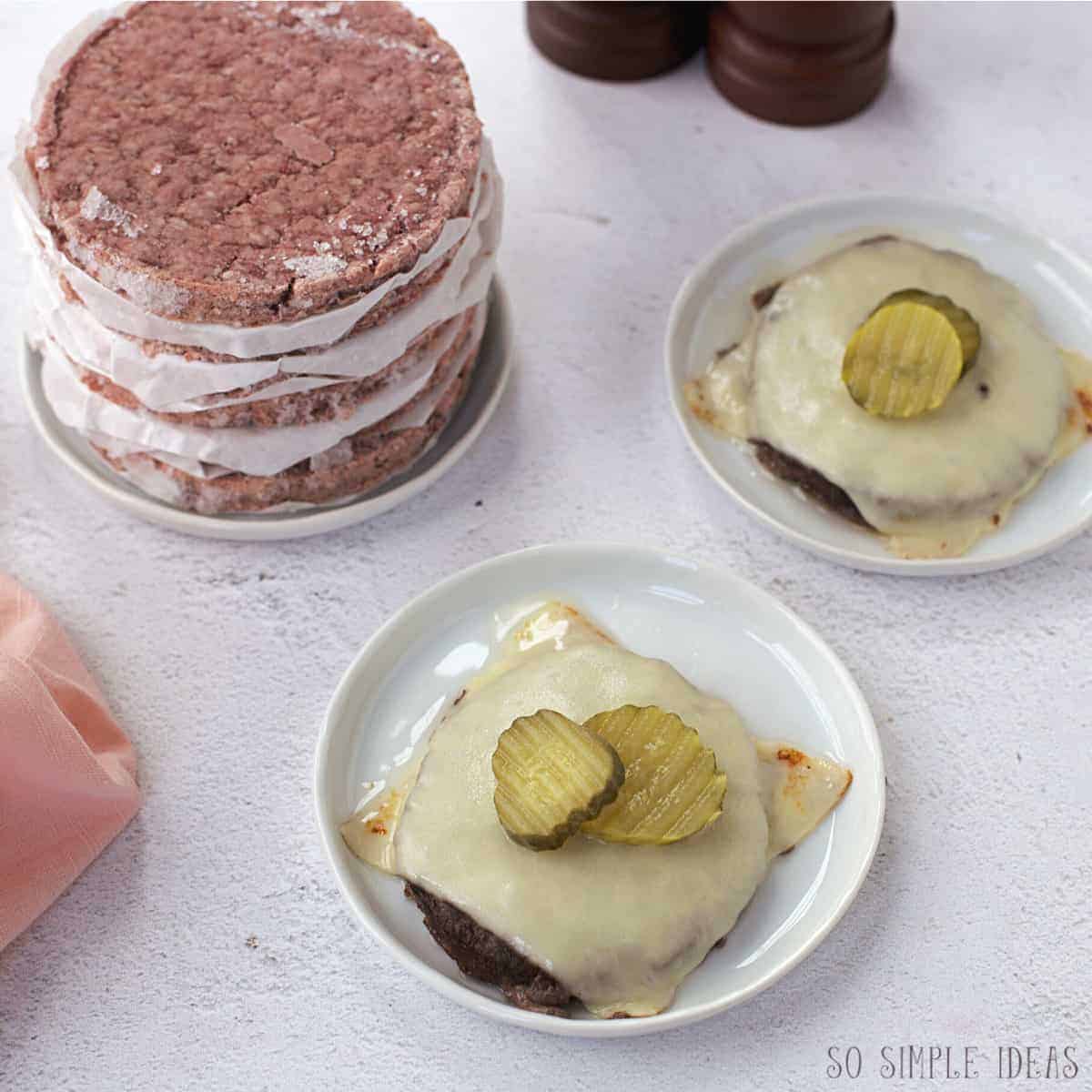 frozen burgers cooked in oven with cheese and pickles.
