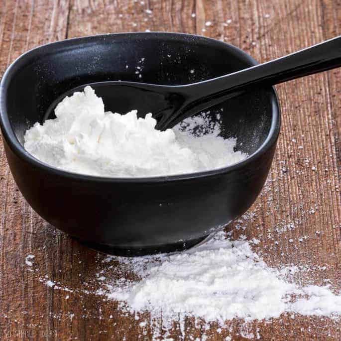 cornstarch in black bowl with spoon.