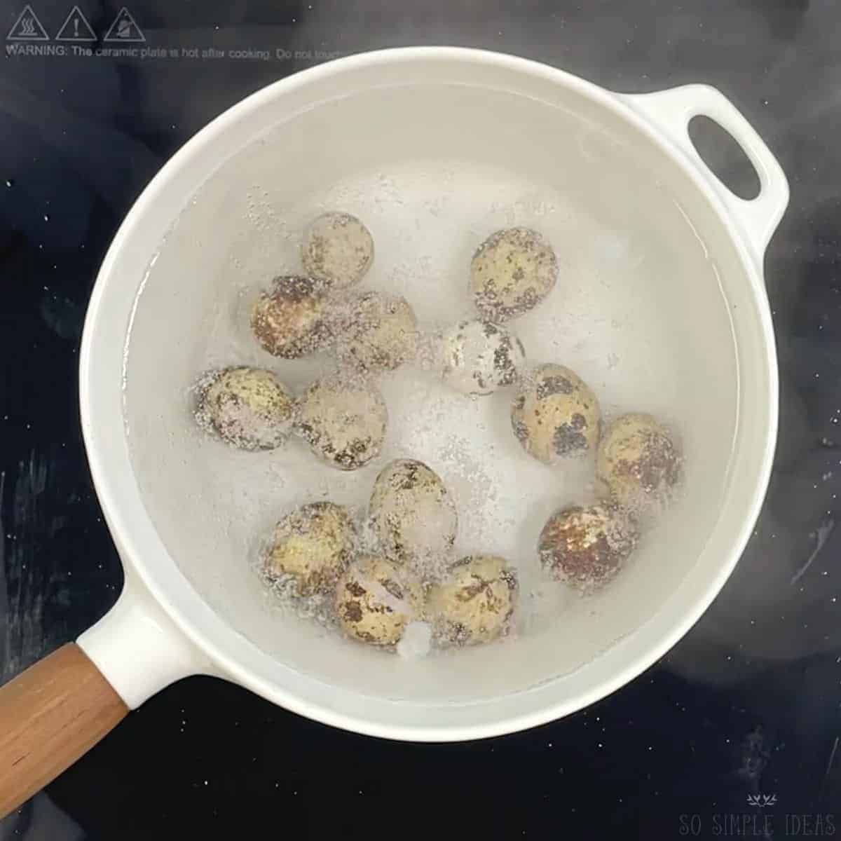 boiling quail eggs in white pot.