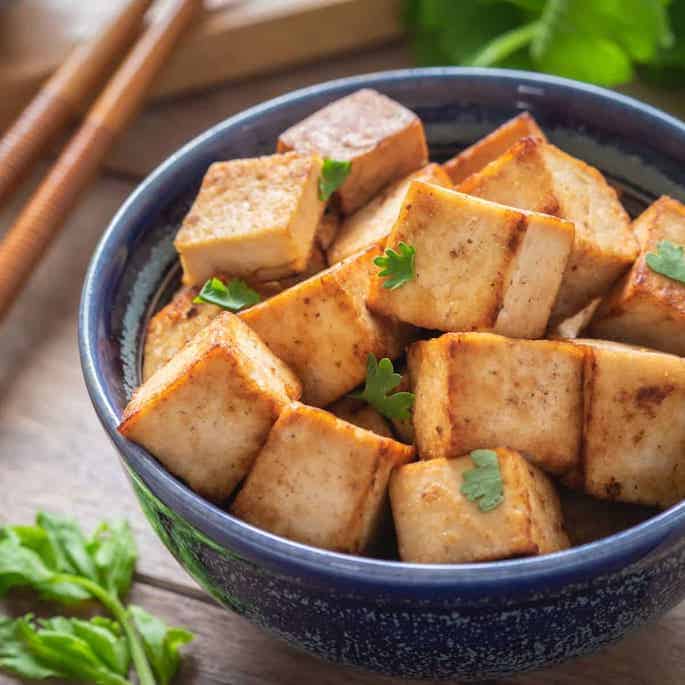 cooked tofu in dark blue bowl.