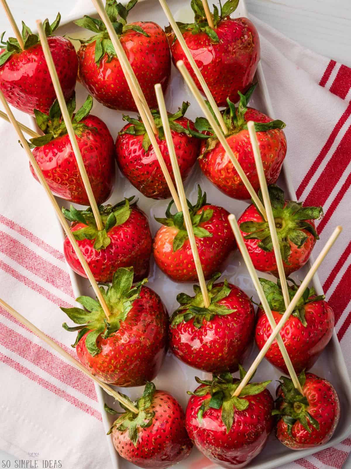 strawberry tanghulu on rectangular plate.