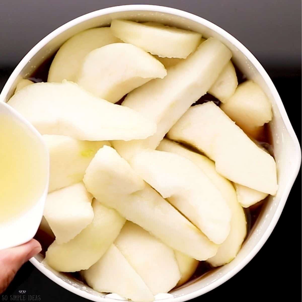 adding lemon juice to pears in pot.