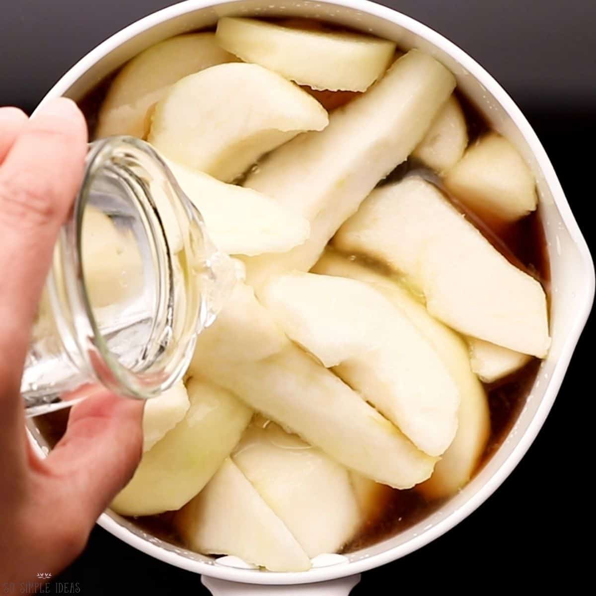adding water to sliced pears in pot.