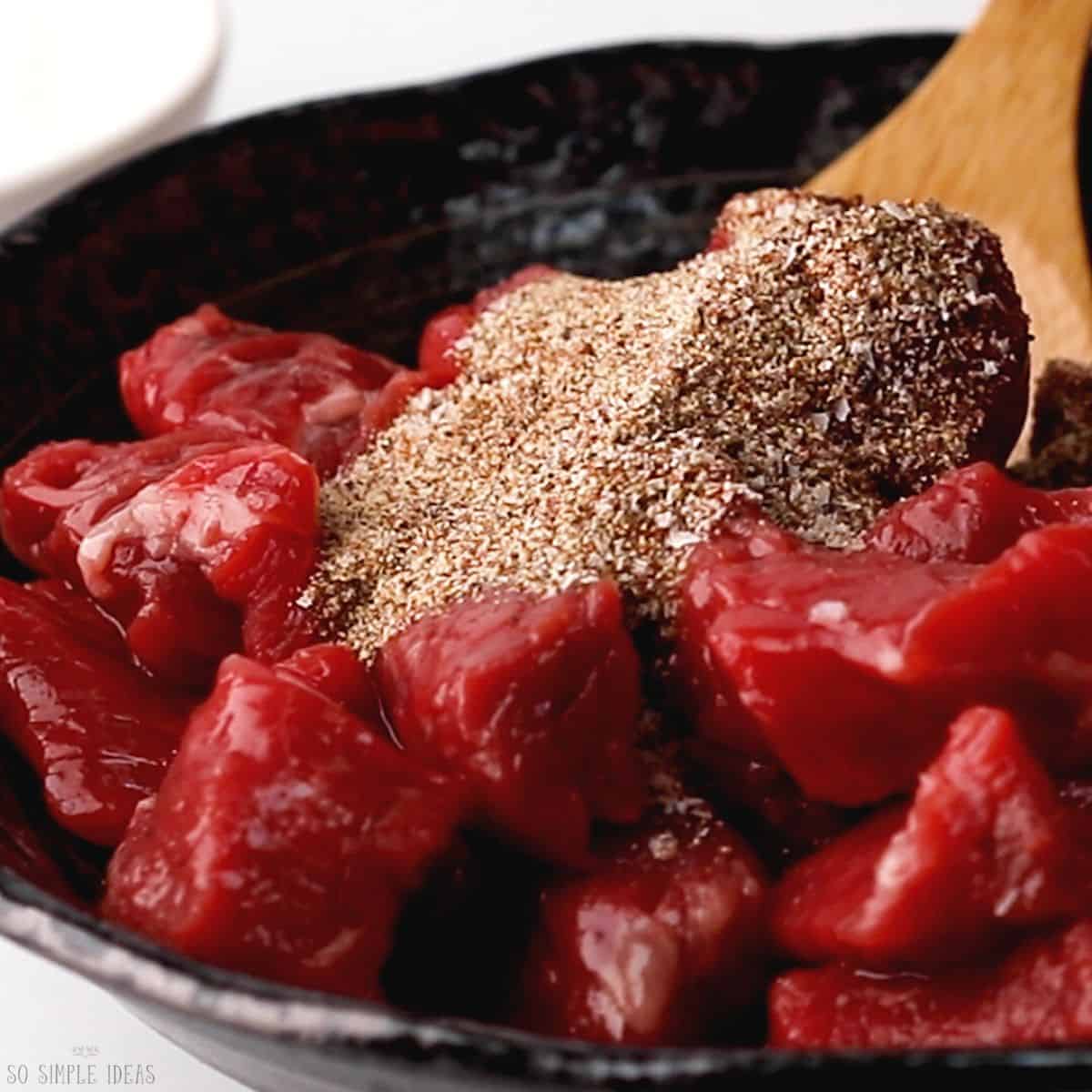 seasoning the steak tips.