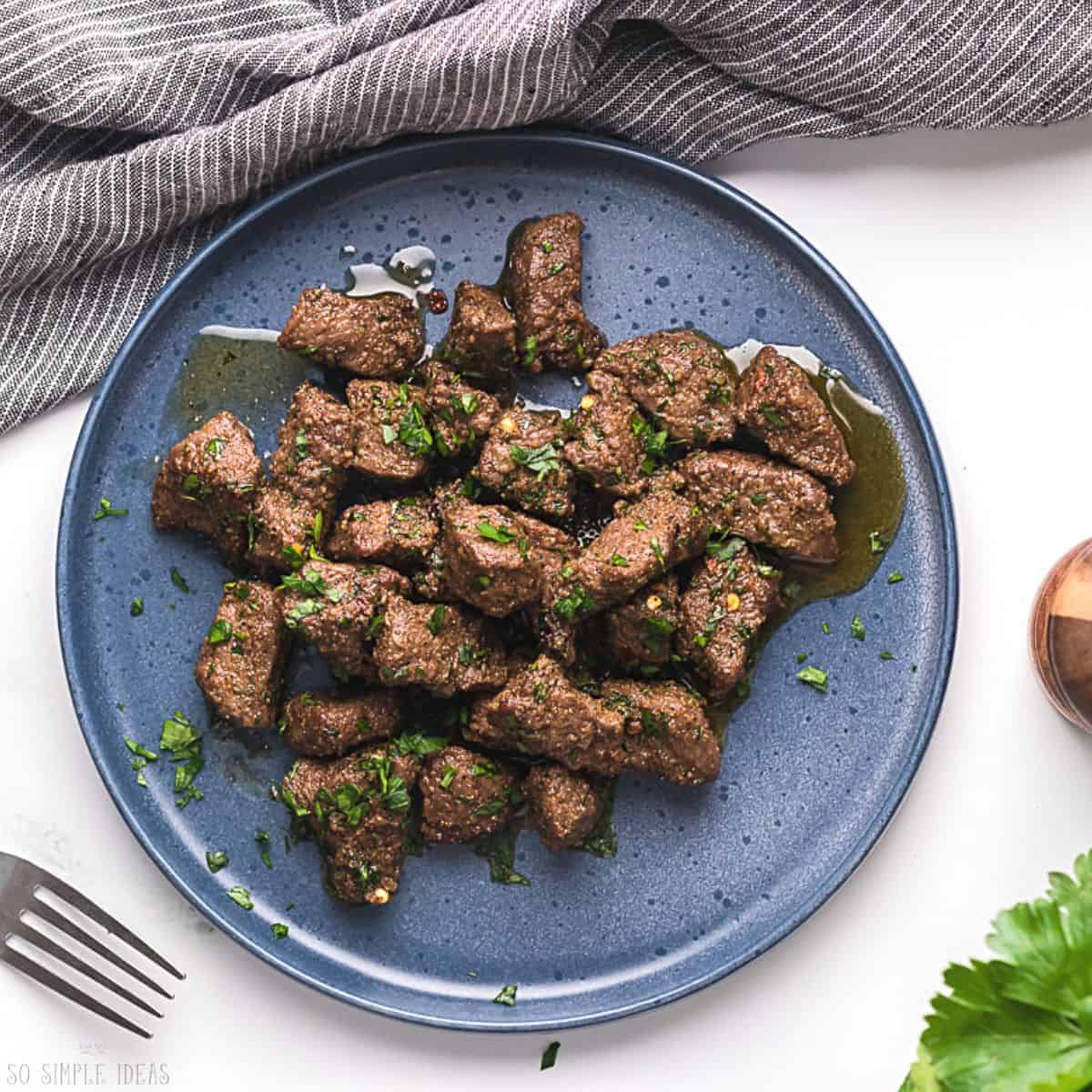 air fryer steak tips on blue plate.