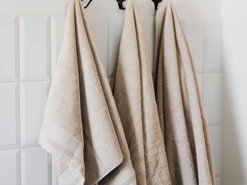 hanging damp towels on hooks.