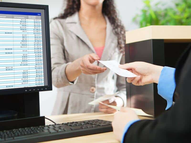 teenager cashing check at bank.