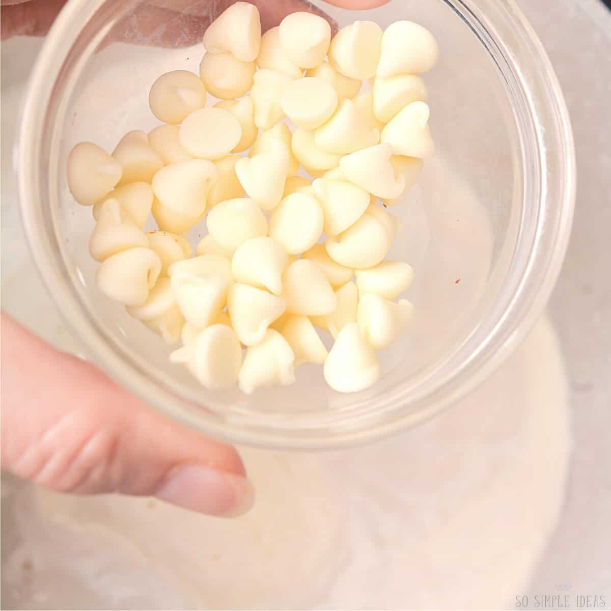 adding white chocolate chips to saucepan.