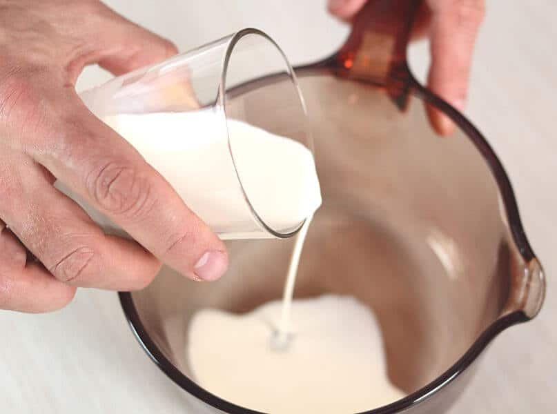 pouring coconut milk into saucepan.