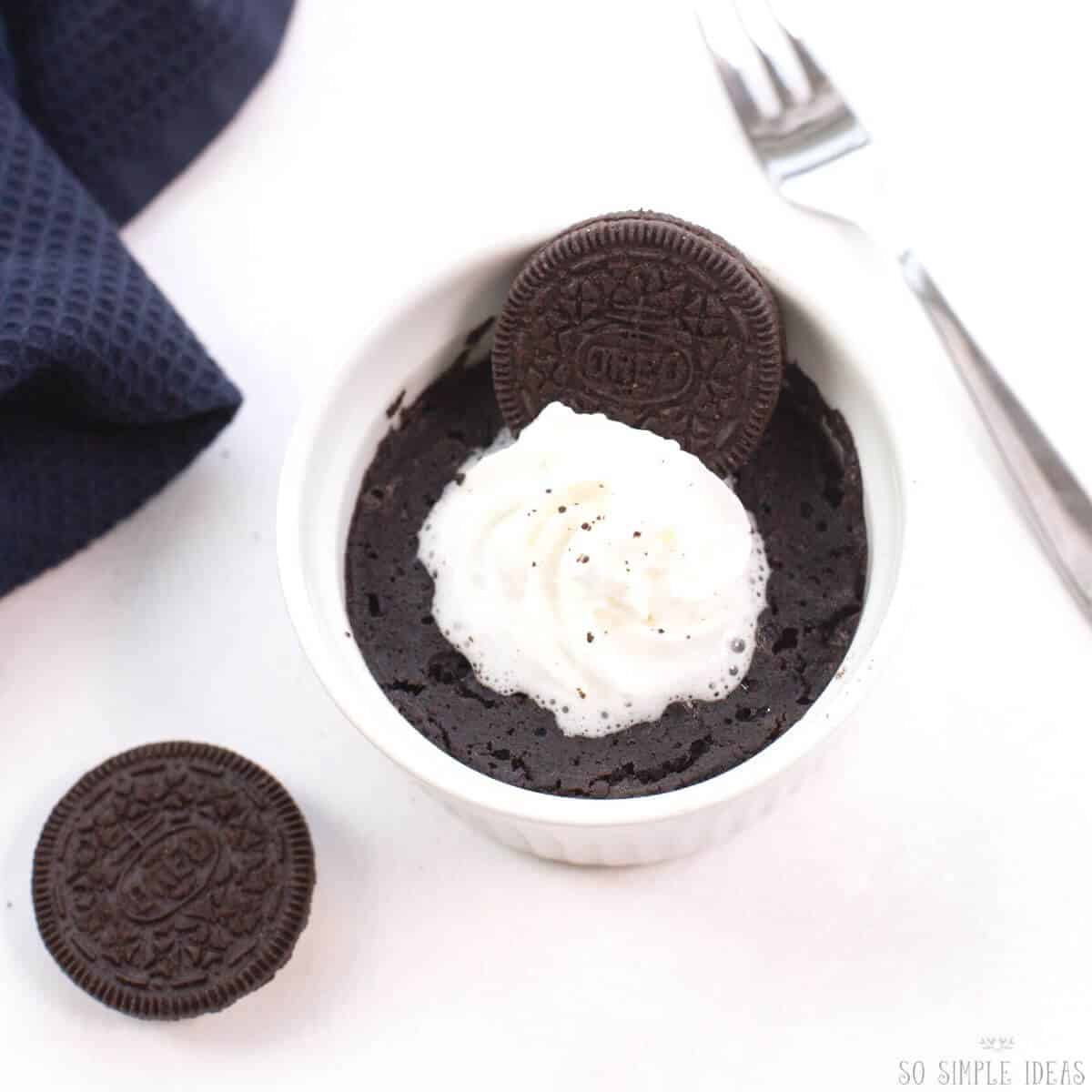 mug cake garnished with whipped cream.